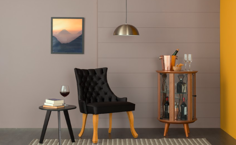 home bar na sala de estar com poltrona, mini adega, mesa de apoio e diversos itens decorativos