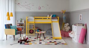 decoração do quarto infantil colorida com tapete colorido e cama amarela