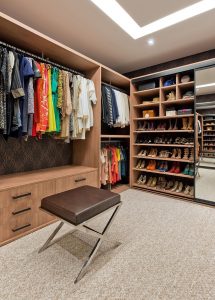 closet organizado de madeira com banqueta para melhorar organizar