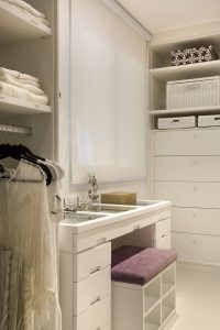 closet organizado com mesa de maquiagem e comoda