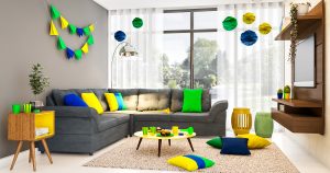 festa em casa com sofá cinza decorado com verde, amarelo e azul