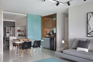 decoração de apartamento pequeno com porta de correr entre a sala e a cozinha