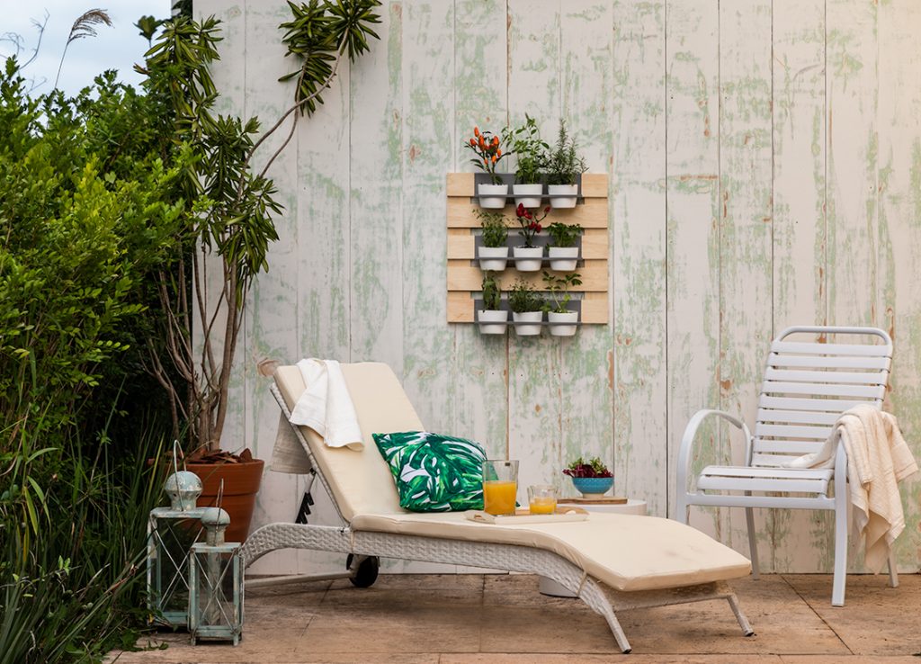 decoração de área externa feita com jardim vertical com suporte de pallets