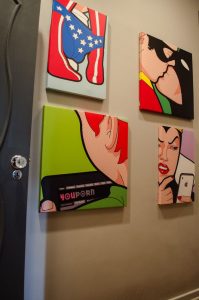 quadros de decoração pop art pendurados próximo a porta