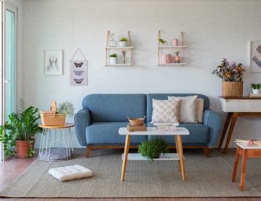 dicas para saber como escolher sofá, com um modelo fixo azul, mesa de centro, aparador e diversos itens decorativos