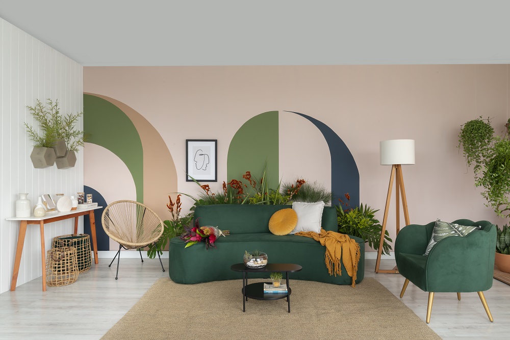 Sala de estar com cores verdes presentes na parede, móveis e decoração