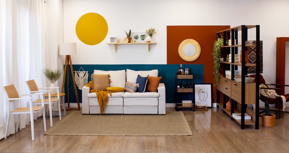 Sala de estar com cores da primavera em destaque como terracota na poltrona, verde nas plantas e acessórios decorativos coloridos.