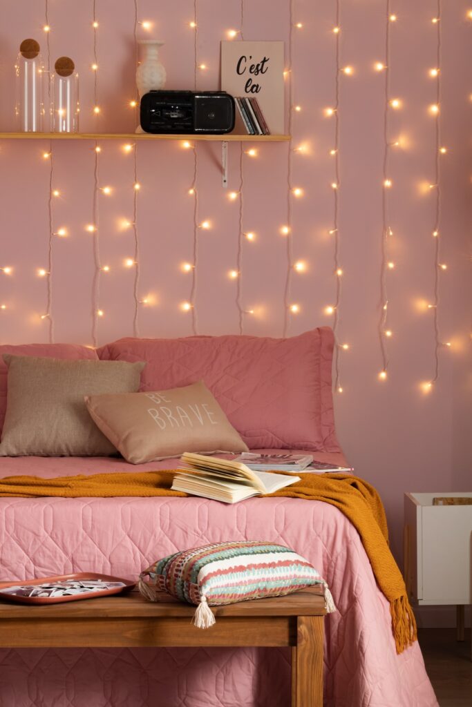 Detalhes de um quarto com vários tons de rosa: parede, roupas de cama e enfeites