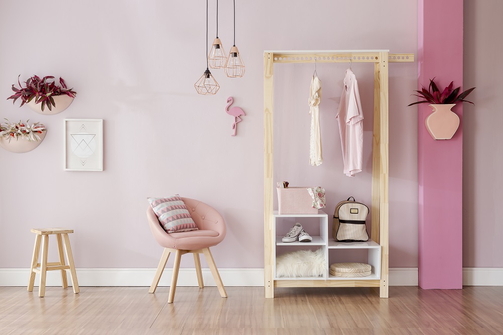 Quarto com parede, móveis e decorativos em tons de rosa