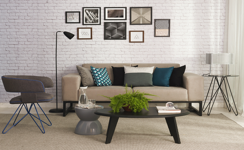 sala de estar com mesa de centro, sofá, mesa lateral, luminária de chão e diversos itens decorativos