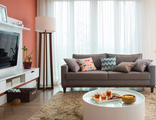 sala de estar moderna com sofá, rack, mesa de centro, luminária de chão em tons neutros