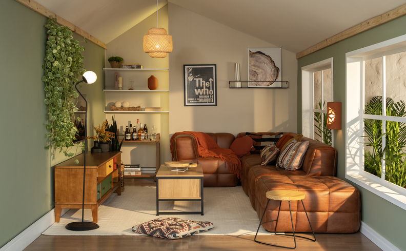 sala de estar com sofá modular, prateleira, rack, mesa de centro entre outros móveis e itens decorativos