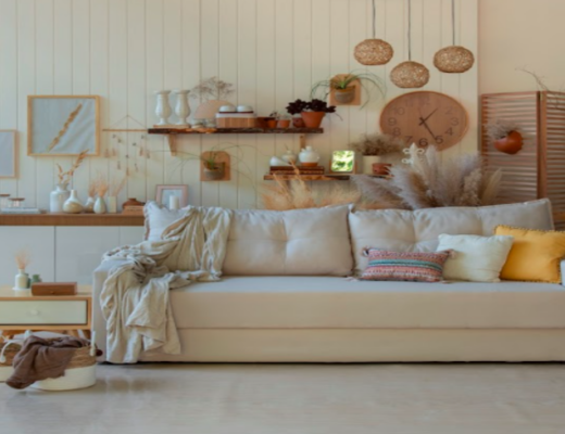 estilo de decoração boho na sala de estar com sofá, almofadas, manta, prateleiras e diversos itens de decoração
