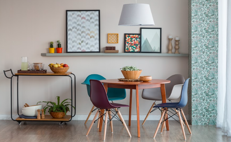 ideias para decoração de casas pequenas com mesa redonda, quatro cadeiras, carrinho usado como fruteira e prateleiras com itens decorativos