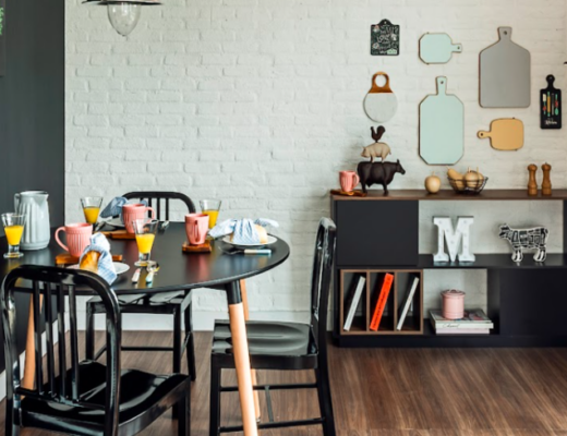 como decorar casa pequena ambiente com mesa de jantar e duas cadeiras, além de uma estante pequena com diversos itens decorativos