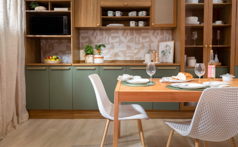 armário de cozinha verde, com nichos, cristaleira, prateleiras, além de mesa e duas cadeiras no ambiente