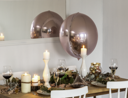decoração com espelho na sala de jantar com modelo retangular próximo a mesa de jantar com velas, pratos e adornos deccorativos