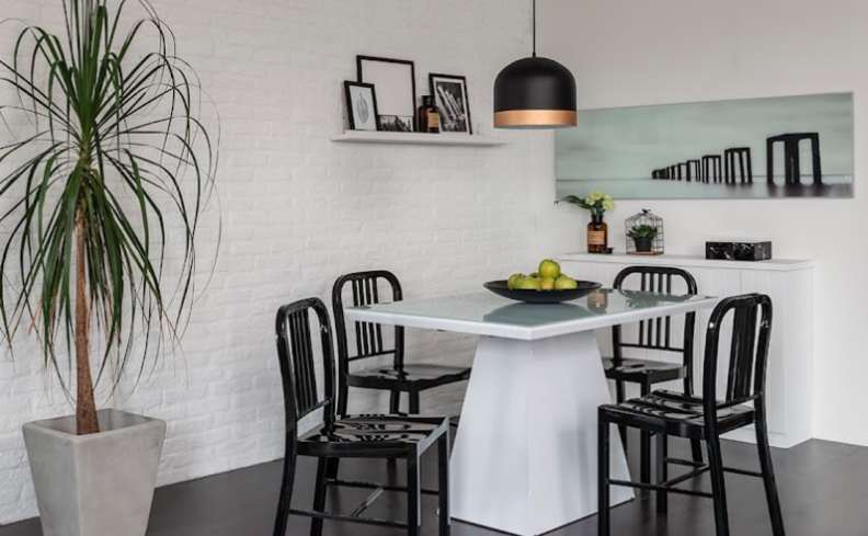 pendente para sala de jantar decorada com mesa retangular, quatro cadeiras, prateleiras e quadros na decoração
