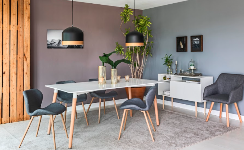sala de jantar com mesa retangular e buffet para ajudar na organização, além de cadeiras, pendentes e uma poltrona