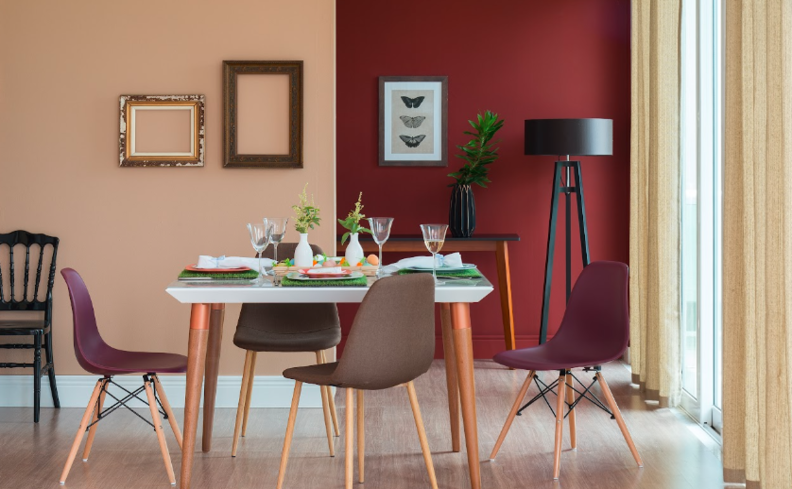 sala de jantar decorada com paredes com tons mais escuros, cadeiras, mesa retangular e quadros na parede, além de uma luminária de chão