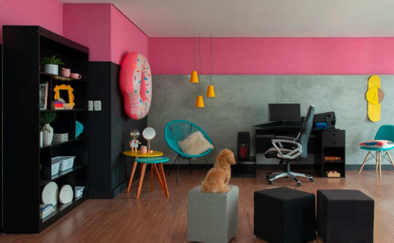 espaço da leitura na sala, com estante, poltrona, mesa de apoio, além de escrivaninha e cadeira de escritório