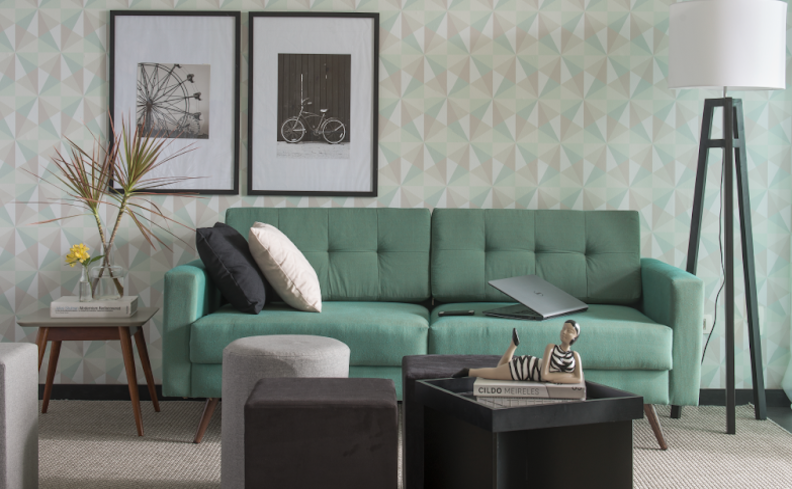 quadros decorativos minimalistas na sala de estar com sofá verde, mesa de centro, puff e almofadas