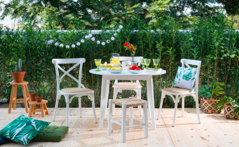 churrasco em casa em uma área externa com cadeiras, mesa e itens decorativos para deixar esse evento completo.