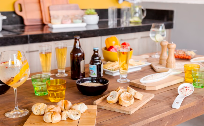 churrasco simples em casa em um ambiente externo com diversas bebidas e comidas para aproveitar nesse evento