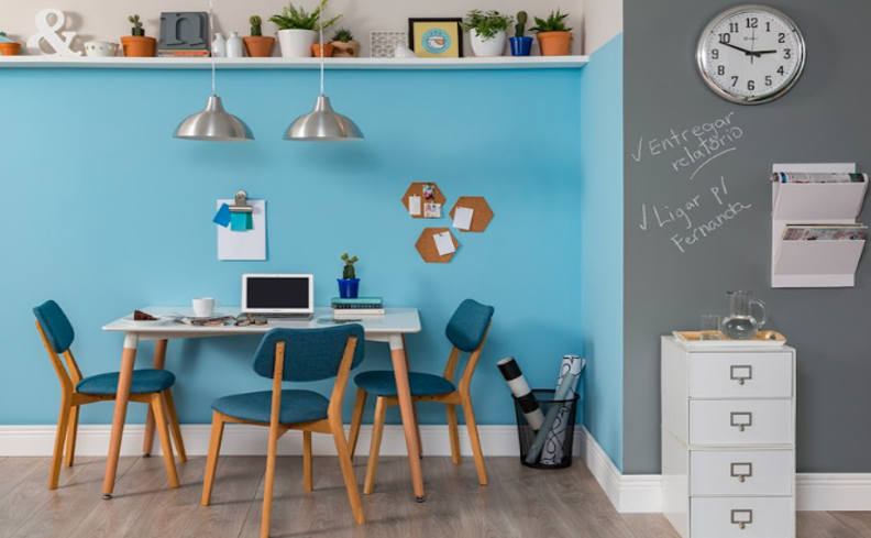 decoração cm tons de azul claro na parede em um ambiente de escritório, com mesa de reunião, cadeiras e prateleiras.