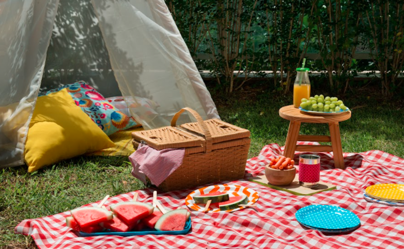 ideia para dia dos namorados em casa com piquenique no jardim, com cabana, cesta, toalha na grama e comidas