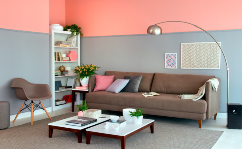 parede pintada de duas cores na sala de estar com sofá, mesa de centro, poltrona e estante, além de diversos itens decorativos
