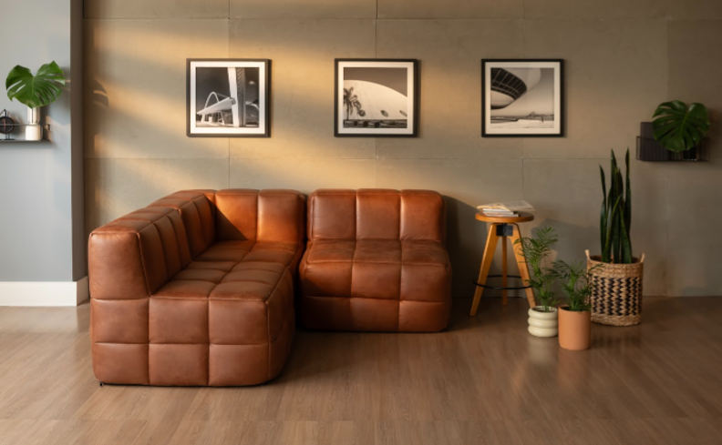 sofá de canto pequeno modular em uma sala de estar pequena com quadros decorativos e plantas.