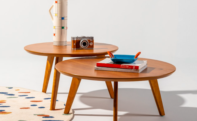 mesa de centro orgânica de madeira, com tapete, itens decorativos sobre a mesa para complementar a decoração.