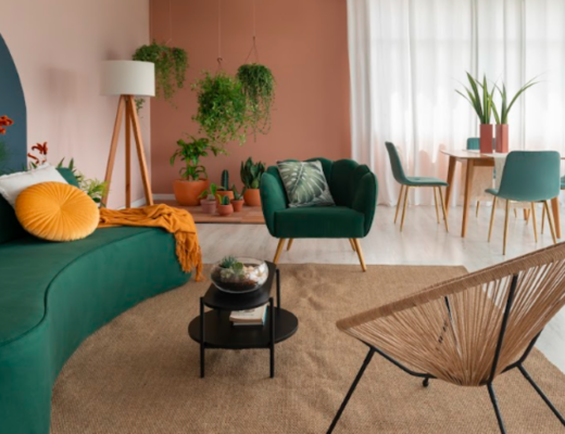 móveis orgânicos na sala de estar com sofá, poltronas, mesa de centro e diversos itens decorativos como luminária de chão e plantas.