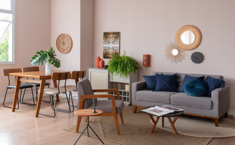 sala de estar com poltronas, sofá, almofadas, mesas de centro e de apoio, com um ambiente integrado com a sala de jantar.