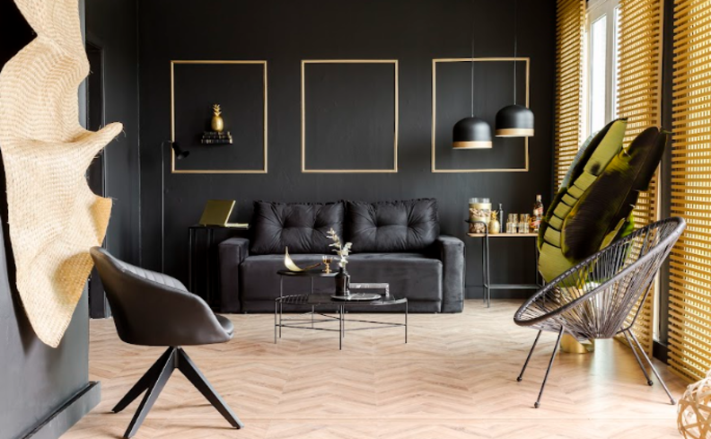 tipos de poltronas na sala de estar com poltrona preta, sofá preto, lustres pendentes e mesa de centro.