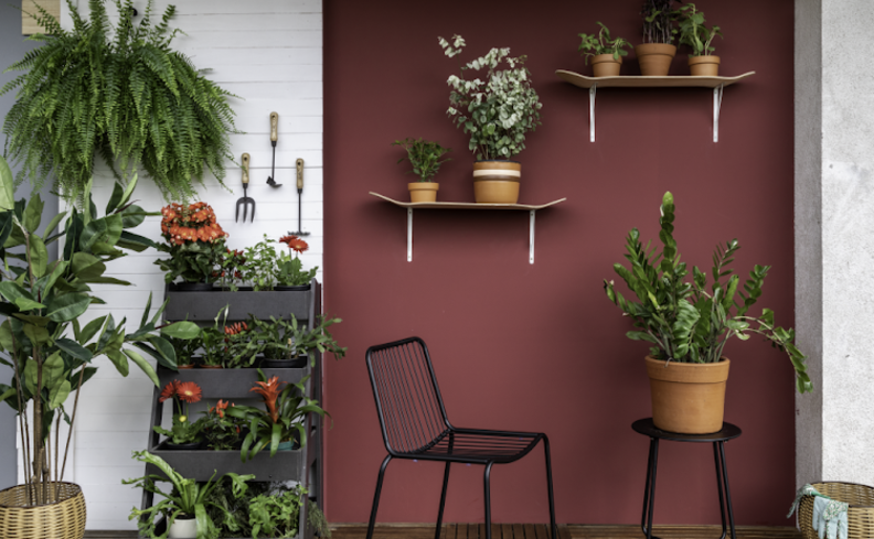 jardim vertical na área externa com diversos tipos de plantas, vasos e cadeiras.