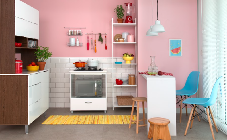 decoração colorida na cozinha com tons pastel de rosa na parede, cadeiras azuis e itens decorativos coloridos para ter uma decoração de primavera simples e bonita.