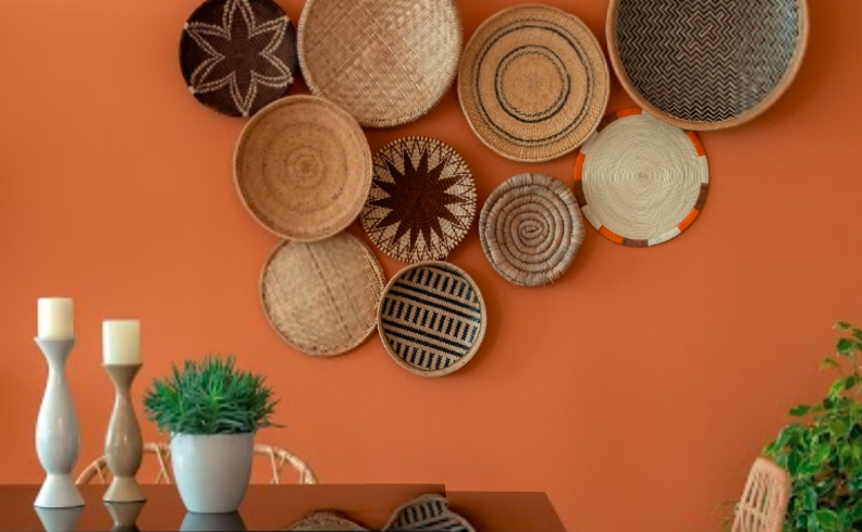 tons de laranja claro na parede, além de quadros decorativos pendurados na parede, um buffet com itens decorativos como castiçal e vaso com plantas.