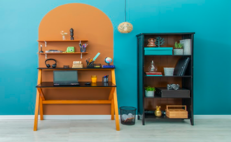 tons de laranja e azul na decoração em um home office com prateleira, escrivaninha e estante com diversos itens de decoração.