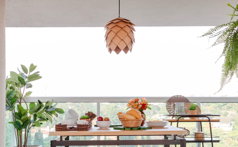 lustres para área externa, além de mesa posta com diversas louças, vasos com plantas e outros objetos decorativos.