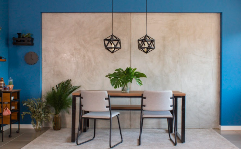 pendente para área externa, além de mesa de madeira, duas cadeiras e diversos vasos com plantas para complementar a decoração.