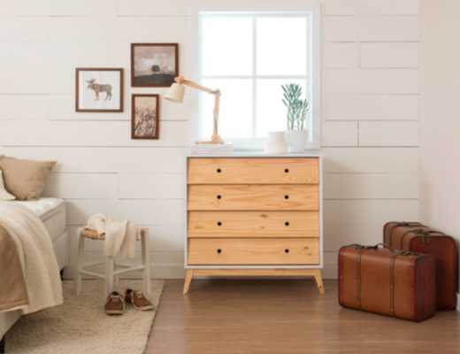 modelos de cômoda para quarto com quatro gavetas, além de cama, tapete, poltrona, luminária de mesa e outros itens decorativos.