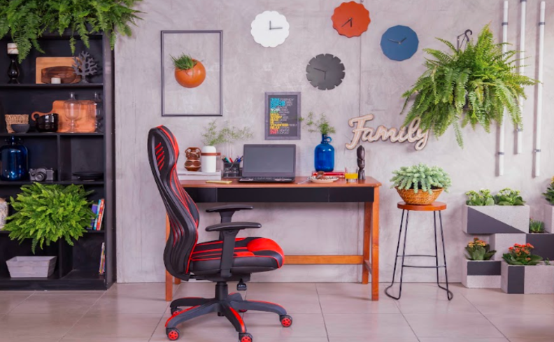 cantinho de estudo com cadeira gamer, escrivaninha, estante, plantas decorativas e outros itens de decoração.