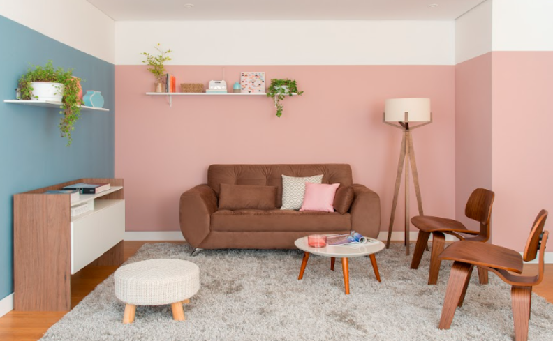 cor parede de sala em tons claros como azul e rosa, além de móveis como sofá, poltronas e rack em tons de marrom para ter equilíbrio na composição.