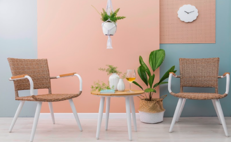 móveis para varanda, duas poltronas e uma mesa de apoio, além de parede em tons de rosa e azul e vasos com plantas para complementar a decoração da área externa.