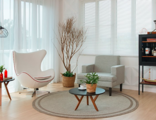 modelo de tapete redondo para a sala de estar, com poltronas, estante e mesas de apoio para complementar a decoração.