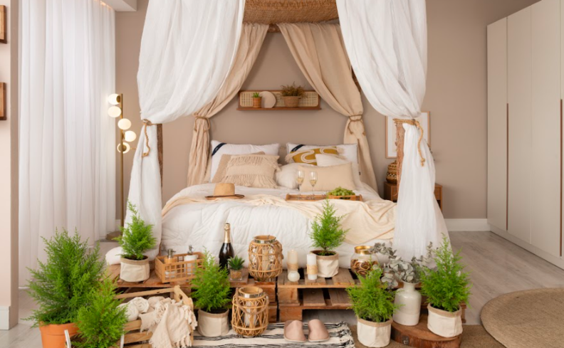 luminária para o quarto em um pendente ao lado da cama, mesa de cabeceira, cama posta e diversos vasos com plantas.