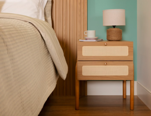 luminária para o quarto em uma mesa de cabeceira de madeira, cama posta em tons neutros e uma xícara de chá para deixar o ambiente bonito e funcional.