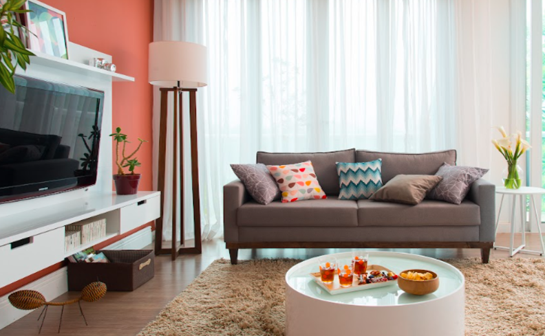 sala cinema em casa com sofá confortável, iluminação, rack, som e diversos itens de decoração.